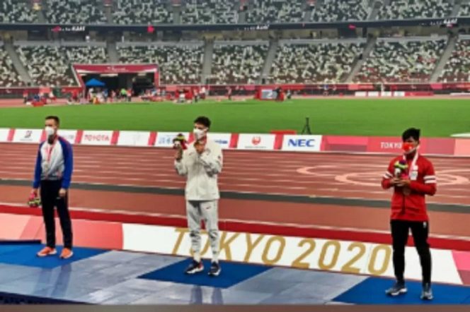 					Saptoyogo Purnomo (merah) seusai menerima medali perunggu dari atletik nomor 100 meter putra T37. ANTARA/HO-KBRI Tokyo (.)