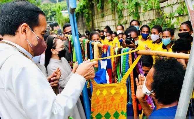 					Presiden Joko Widodo membeli tas rajutan asli Papua atau Noken, dari Mama-Mama penjual di Jalan Raya Hawai Sentani, Jayapura, Papua, Jumat (1/10/2021). ANTARA/HO-Biro Pers Sekretariat Presiden/Laily Rachev/pri.