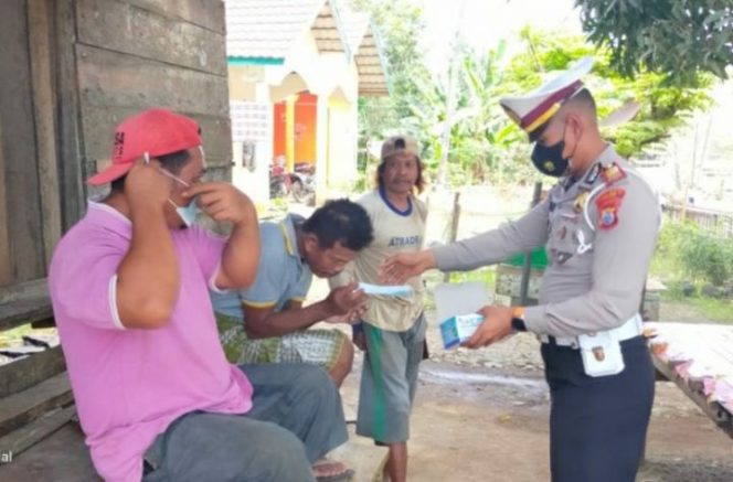 					Sambil Bagi Bansos, Kasat Lantas Polres Bone Tebar Masker, Ajak Warga Jaga Prokes