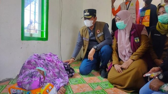 					Bupati Luwu H. Basmin Mattayang didampingi Kadis Kesehatan dr. Rosnawary Basir, memeriksa kesehatan salah seorang warga di pengungsian.
