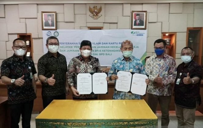 					Direktur Kepesertaan BPJS Ketenagakerjaan Zainudin bersama Dirjen Perikanan Tangkap Kementerian Kelautan dan Perikanan Muhammad Zaini menunjukkan perjanjian kerja sama yang telah ditandatangani di Denpasar, Jumat (10/12/2021). ANTARA/Ni Luh Rhismawati.