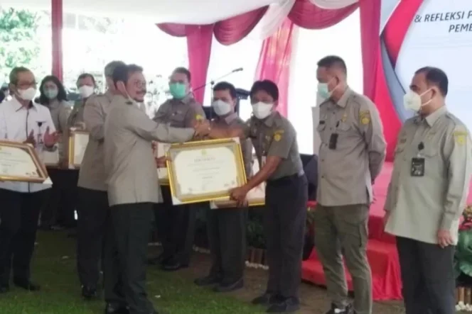 					Menteri Pertanian Syahrul Yasin Limpo menyerahkan sertifikat penghargaan kepada 10 Unit Pelaksana Teknis (UPT) lingkup Kementerian Pertanian yang berhasil membangun Zona Integritas Wilayah Bebas dari Korupsi (WBK) pada peringatan Hari Anti Korupsi Sedunia (Hakordia) di Kementerian Pertanian, Jakarta, Senin (13/12/2021) (Antara/Subagyo)