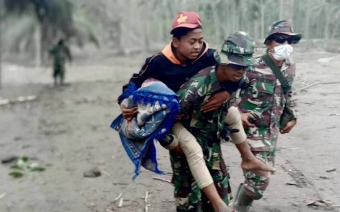 					Prajurit TNI AU membopong seorang warga yang menjadi korban letusan Gunung Semeru di Lumajang, Jawa Timur, Senin (6/12/2021). ANTARA/HO-Dinas Penerangan TNI AU