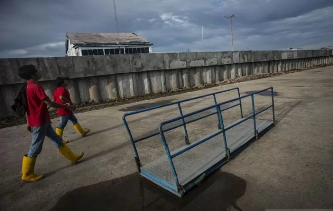 					Warga beraktivitas di dekat tanggul laut yang telah selesai dibangun di Pelabuhan Kali Adem, Muara Angke, Jakarta, Senin (11/2/2019). ANTARA FOTO/Aprillio Akbar/pras.