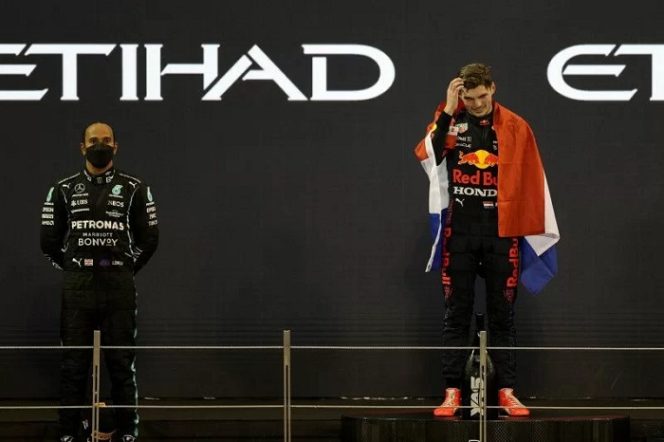 					Pebalap Red Bull Max Verstappen merayakan kemenangan sekaligus menjadi juara dunia dengan bendera Belanda di podium, sementara pebalap Mercedes Lewis Hamilton tampak sedih setelah finis di urutan kedua Grand Prix Abu Dhabi di Sirkuit Yas Marina, Abu Dhabi, Uni Emirat Arab, 12Desember 2021. ANTARA/REUTERS/Rula Rouhana.