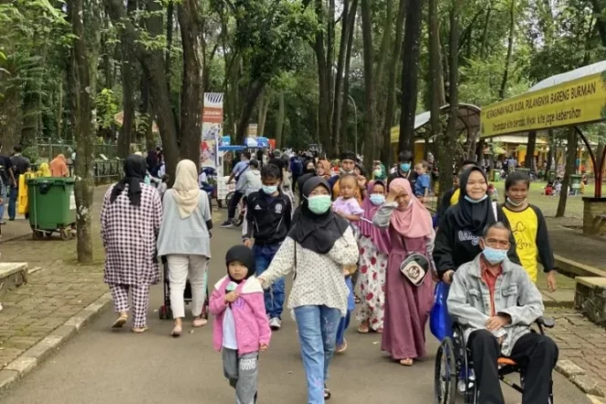 					Pengunjung datang beramai-ramai ke dalam Taman Margasatwa Ragunan di Jakarta untuk menghabiskan awal tahun baru bersama keluarga pada Sabtu (1/1/2022). ANTARA/Hreeloita Dharma Shanti.