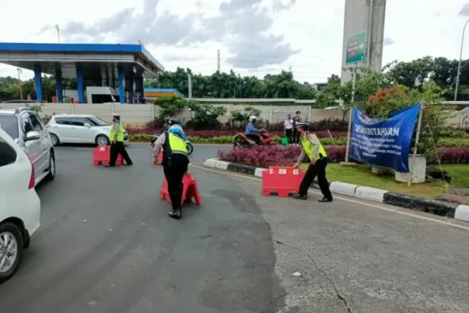 					Polisi mengatur barier pembatas jalan selama penerapan ganjil genap di sekitar kawasan TMII, Jakarta Timur, Sabtu (1/1/2022). ANTARA/Andi Firdaus.