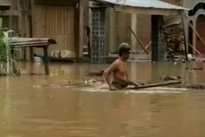 					Warga melintasi genangan banjir di Julok, Kabupaten Aceh Timur, Jumat (31/12/2021). ANTARA/HO.