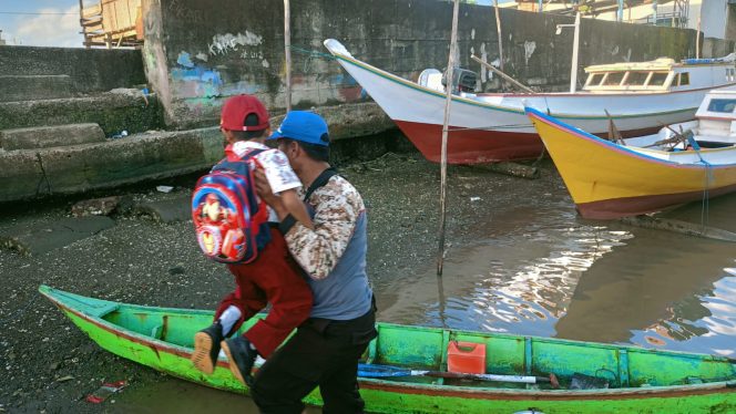 					Personel Satpolair Polres Sinjai Membantu Bocah SD yang Menyebrangi Sungai untuk ke Sekolah. (Dok. Ist/ Humas Polres)