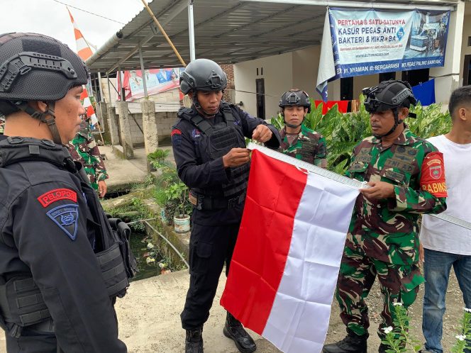 					Patroli Bersama, Personel Brimob dan Kodim Bone Bagi-bagi Bendera ke Warga