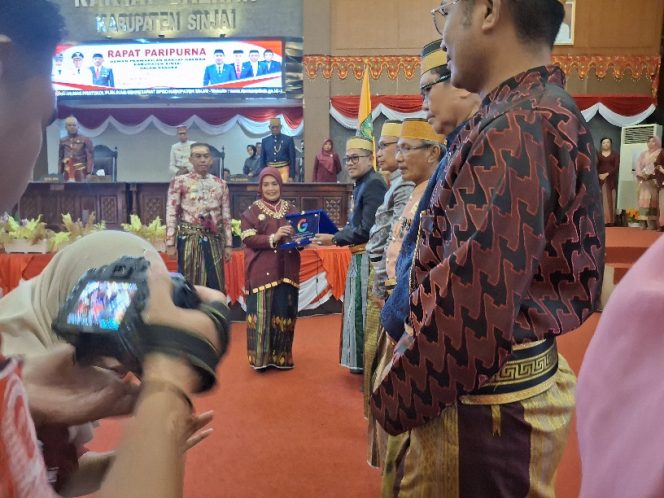 					Bupati Sinjai, Ratnawati Arief Serahkan Plakat KSRG kepada Kepala Sekolah SMP. (Foto: Berita.News/ Syarif)