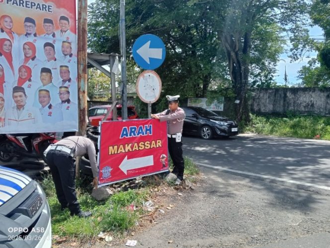 					Personel Sat Lantas Polres Parepare Memasang Petunjuk Arah Jalur Alternatif. (Foto: Istimewa)