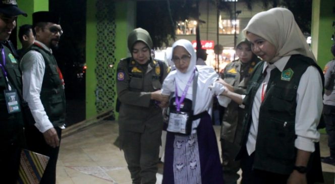 					Petugas Keamanan dan Kemenag Membantu CJH Lansia. (Berita.News/ Wahyu)