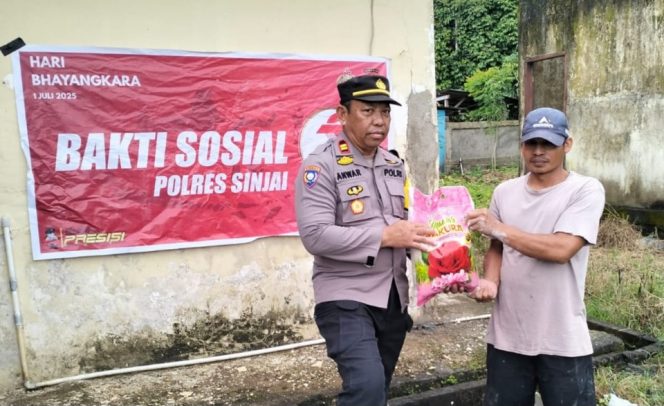 					Kapolsek Sinjai Selatan, Iptu Anwar Menyerahkan Bantuan Sembako ke Warga. (Foto: Istimewa)