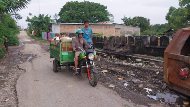 					Aipda Ahmad Syarifuddin Mengangkut Sampah Warga BTN Puri Asri Bulukumba. (Foto: Istimewa)