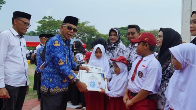 					Bupati Bulukumba Andi Muchtar Ali Yusuf Menyerahkan Secara Simbolis Bantuan Seragam Sekolah Gratis ke Siswa. (Foto: Istimewa)