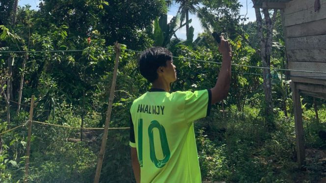 					Salah Seorang Warga yang Sedang Mencari Akses Jaringan Seluler dan Internet. (Foto: Istimewa)