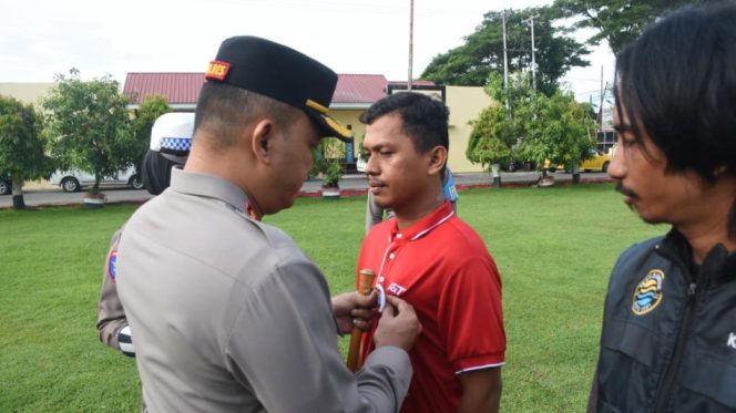 					Kapolres secara simbolis menyematkan Pin Polantas Mappattabe kepada lima perwakilan ojol dan kurir, sekaligus memasangkan helm standar keselamatan. (Foto: Ist/ Humas)