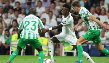 Pemain depan Real Madrid asal Brasil, Vinicius Junior, berebut bola dengan bek Real Betis asal Senegal, Youssouf Sabaly, selama pertandingan sepak bola liga Spanyol antara Real Madrid CF dan Real Betis di stadion Santiago Bernabeu, Madrid, pada 1 September 2024.Thomas COEX / AFP