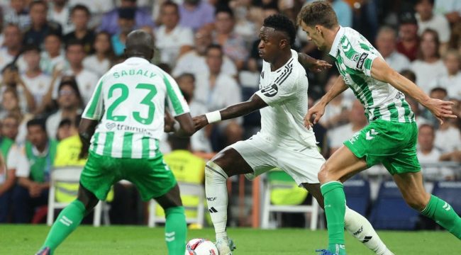 Pemain depan Real Madrid asal Brasil, Vinicius Junior, berebut bola dengan bek Real Betis asal Senegal, Youssouf Sabaly, selama pertandingan sepak bola liga Spanyol antara Real Madrid CF dan Real Betis di stadion Santiago Bernabeu, Madrid, pada 1 September 2024.Thomas COEX / AFP