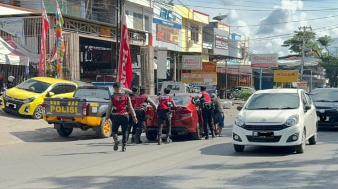 					Personel Samapta Polres Bulukumba Dorong Mobil Mogok di Tengah Kota. [Foto: Ist]