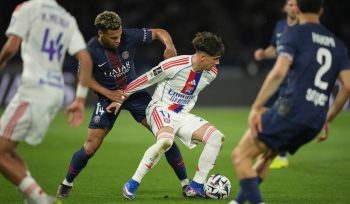 Pemain Lyon, Afonso Moreira (kanan tengah), berebut bola dengan pemain PSG, Desire Doue, dalam pertandingan Ligue 1, Senin (20/4/2026) dini hari WIB. (c) AP Photo/Christophe Ena